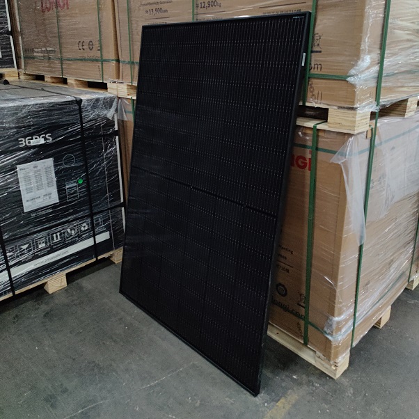 Et 400w all black Astro solcellepanel, der læner sig op ad en palle, så man kan få en idé om størrelsesforholdet